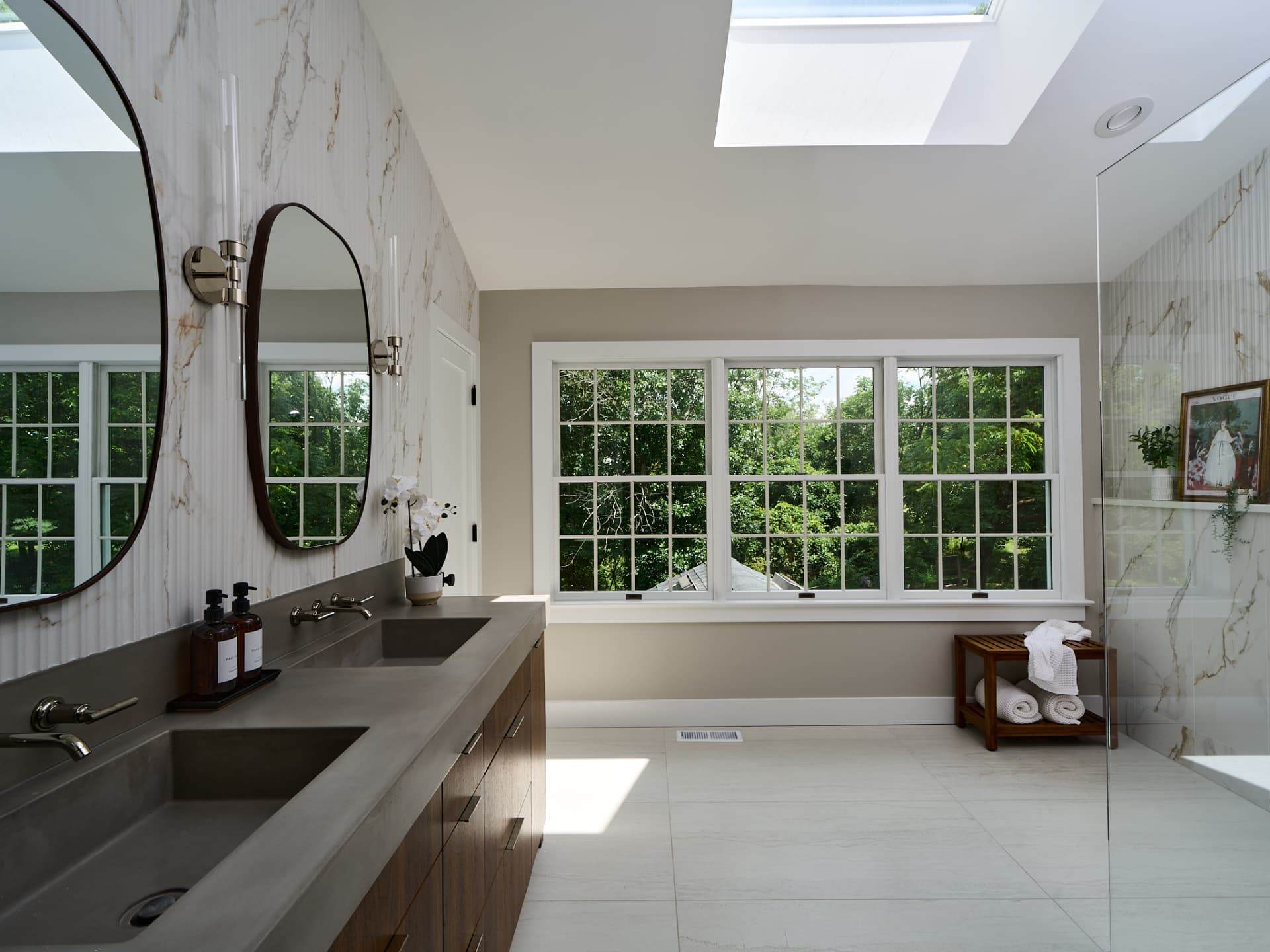 Skylit primary bathroom remodel in Doylestown PA with a long concrete double vanity under windows